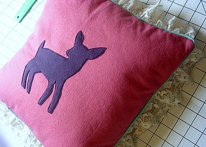 Felt patch stitched onto a pillow using a sewing machine.